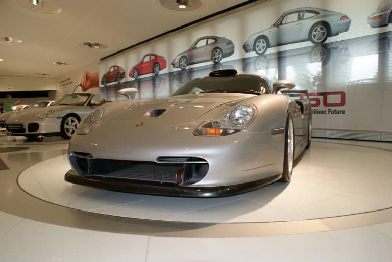 Silver 1997 Porsche 911 GT1 road car on display in the Porsche Museum.