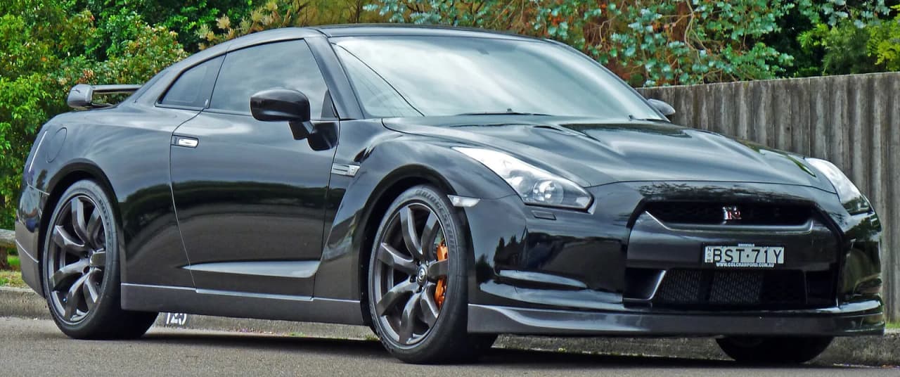 Black Nissan GT-R (R35) coupe parked on a street.