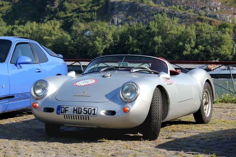 Silver Porsche 550 Spyder racing roadster parked on cobblestones