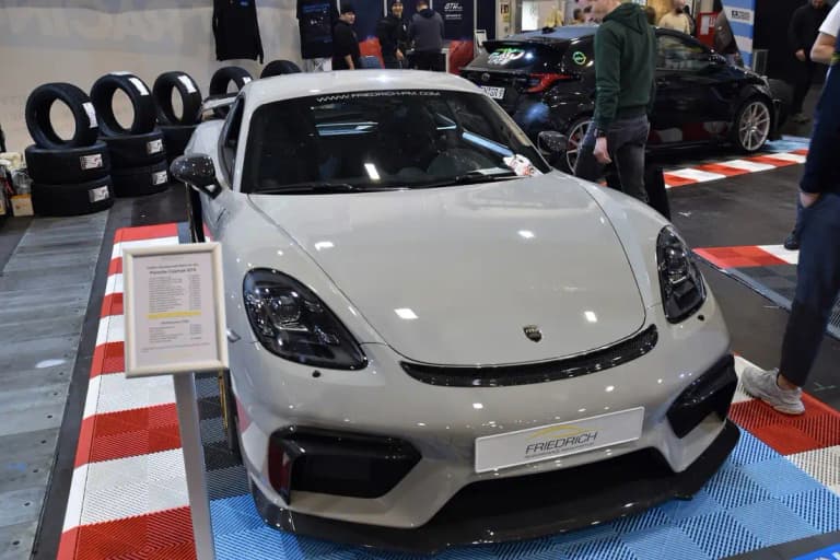 Blue Porsche 718 GT4 parked on grass with front splitter visible