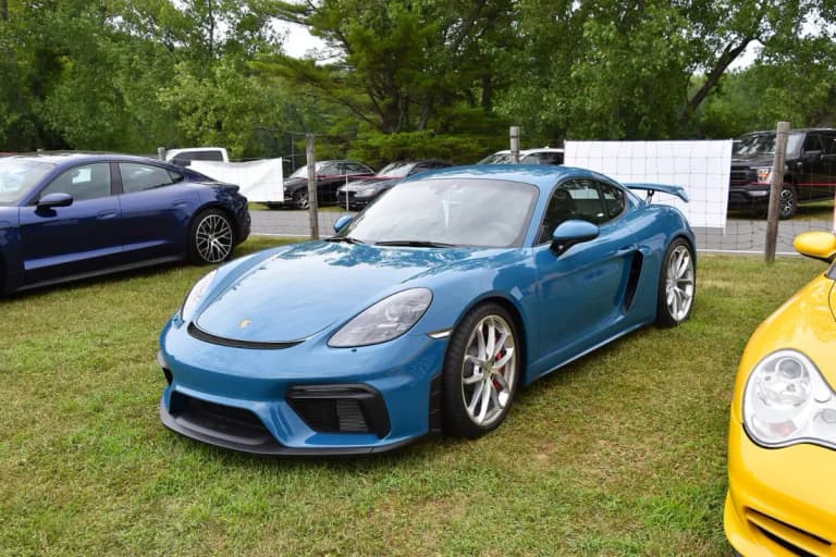 White Porsche 718 GT4 rear three-quarter view showing fixed rear wing