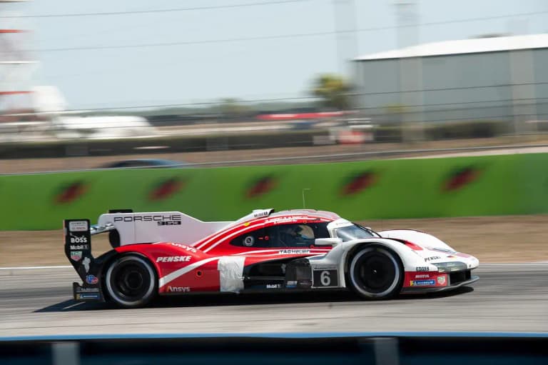 Number 6 Porsche 963 in red and white Penske livery at speed at Sebring