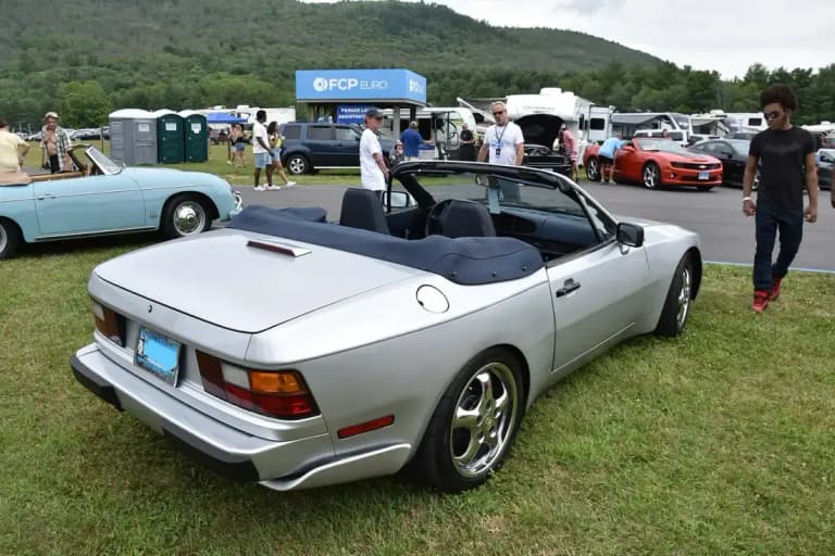 Silver Porsche 944 S2 Cabriolet with the top folded down, rear three-quarter view