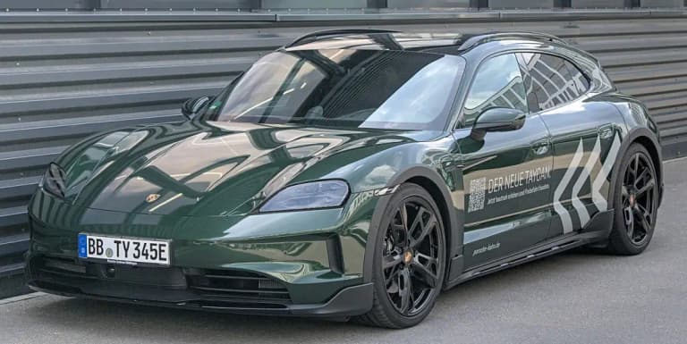 Dark green Porsche Taycan Cross Turismo wagon parked outside a dealership