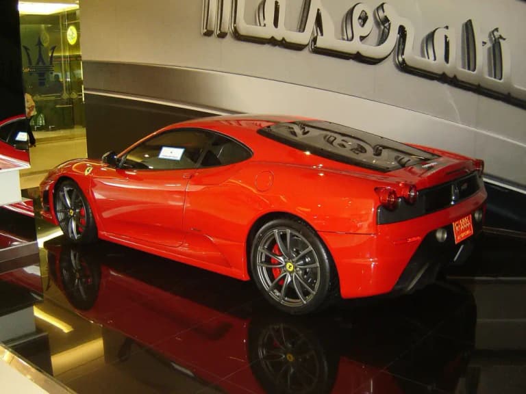 Red Ferrari F430 on display in a luxury car showroom