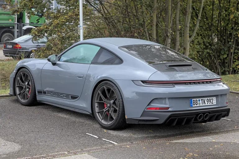 Grey Porsche 992 GT3 Touring parked outdoors, rear three quarter view