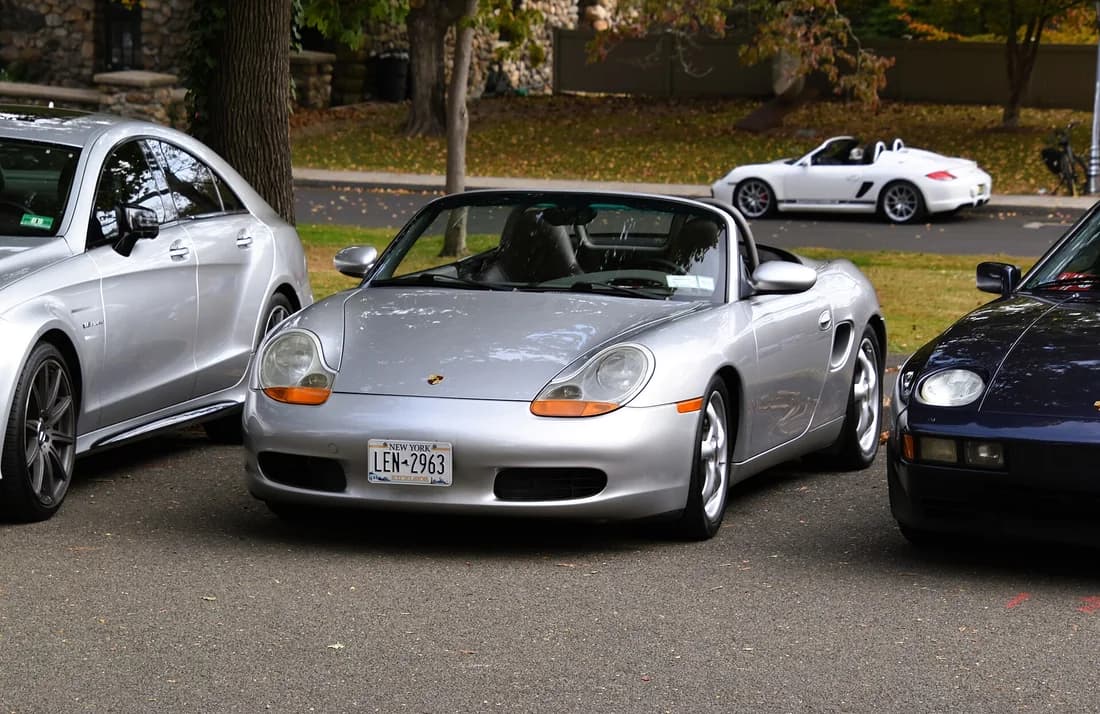 Silver 1999 Porsche 986 Boxster showing the early amber headlamp sections and pre-facelift front bumper