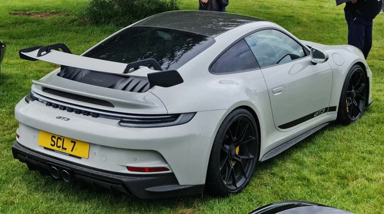 Grey Porsche 992 GT3 with swan-neck rear wing, rear view