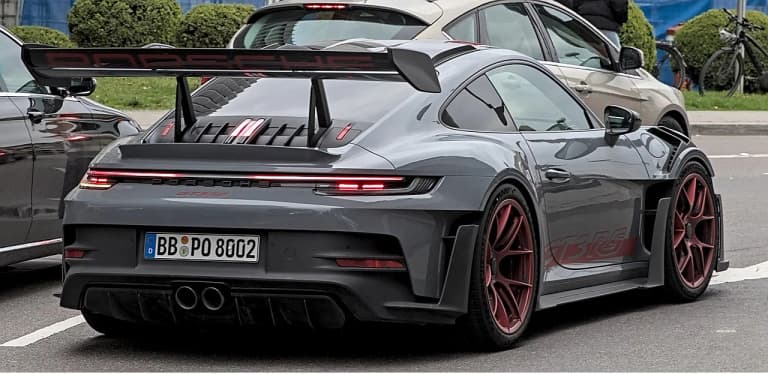 Gray Porsche 992 GT3 RS rear three quarter view with large rear wing
