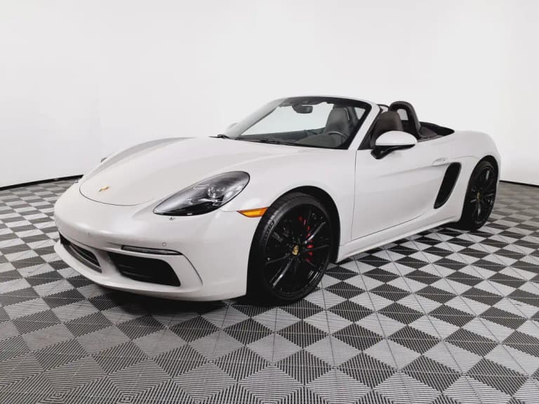 White Porsche 718 Boxster S roadster with the roof down, the convertible in the cayman vs boxster pair