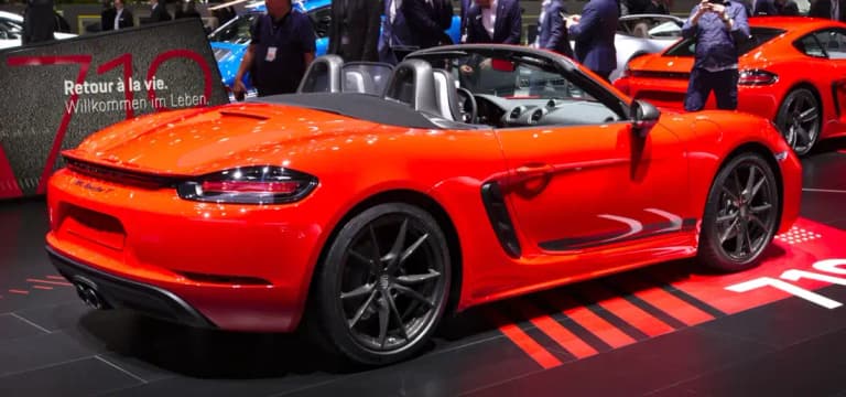 Orange Porsche 718 Boxster T roadster rear three-quarter view at a motor show