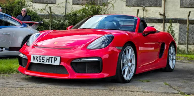 Red 981 Porsche Boxster Spyder roadster parked on tarmac