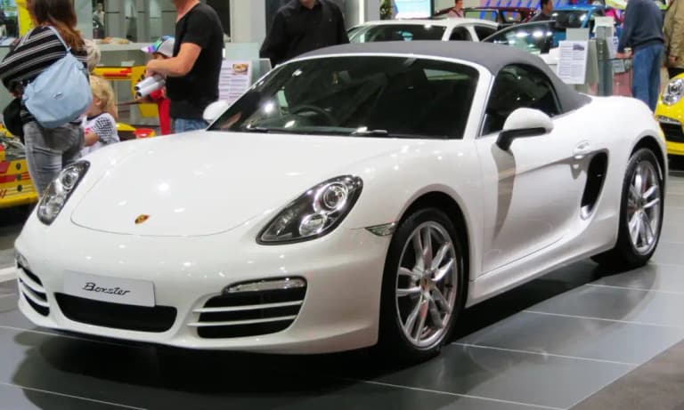 White 981 Porsche Boxster roadster with the roof raised at a car show