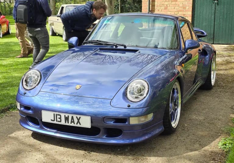 Blue Porsche 911 993 Carrera coupe parked on a driveway