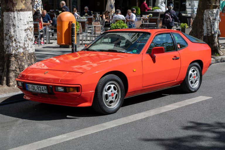 Red Porsche 924 coupe parked on a street