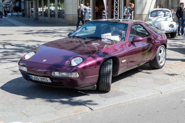 Purple Porsche 928 GTS with flared rear arches parked on a street