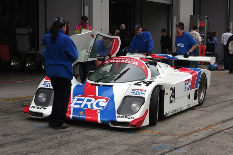 White red and blue Kremer Porsche 962 number 24 in the pit lane with crew