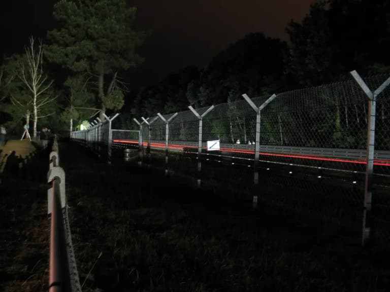 Night scene at the Le Mans circuit with race car light trails along the track