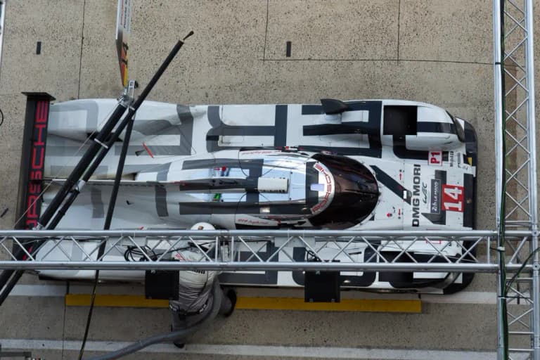 White Porsche 919 Hybrid number 14 race car during a pit stop seen from above