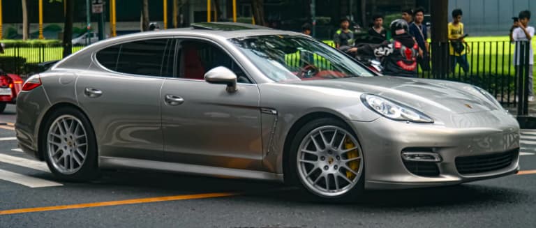 Silver first-generation Porsche Panamera 970 Turbo in side profile on a city street