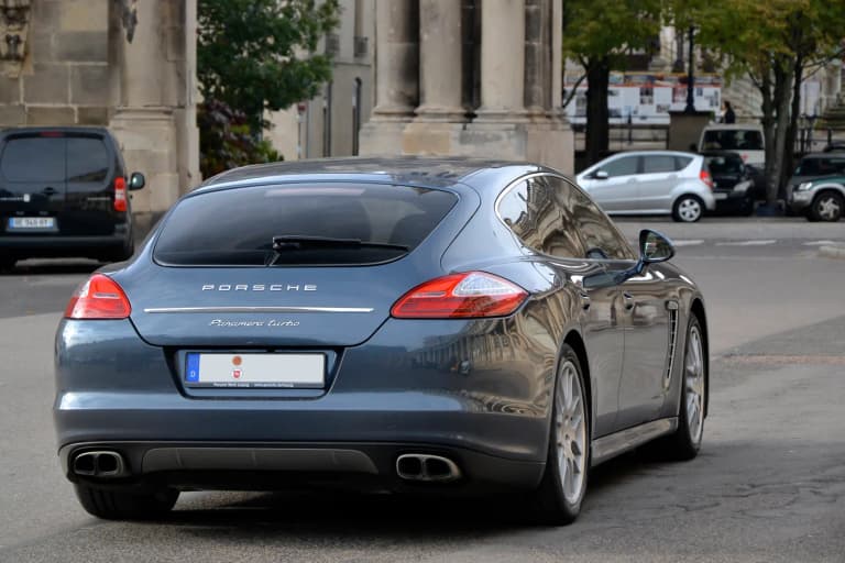 Blue-gray first-generation Porsche Panamera 970 Turbo rear view on a Paris street