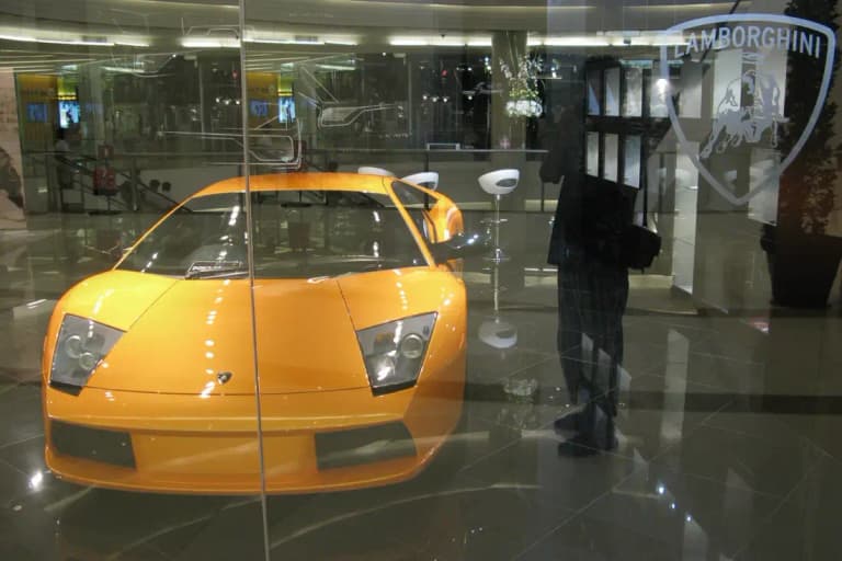 Orange Lamborghini Murcielago behind glass at a Lamborghini showroom inside a Bangkok mall