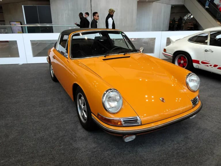 Orange 1968 Porsche 911 S Targa with the classic long hood body on display indoors