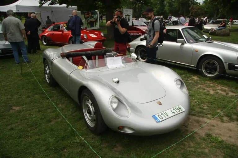 Silver 1957 Porsche 718 RSK race car with red interior at a classic car show