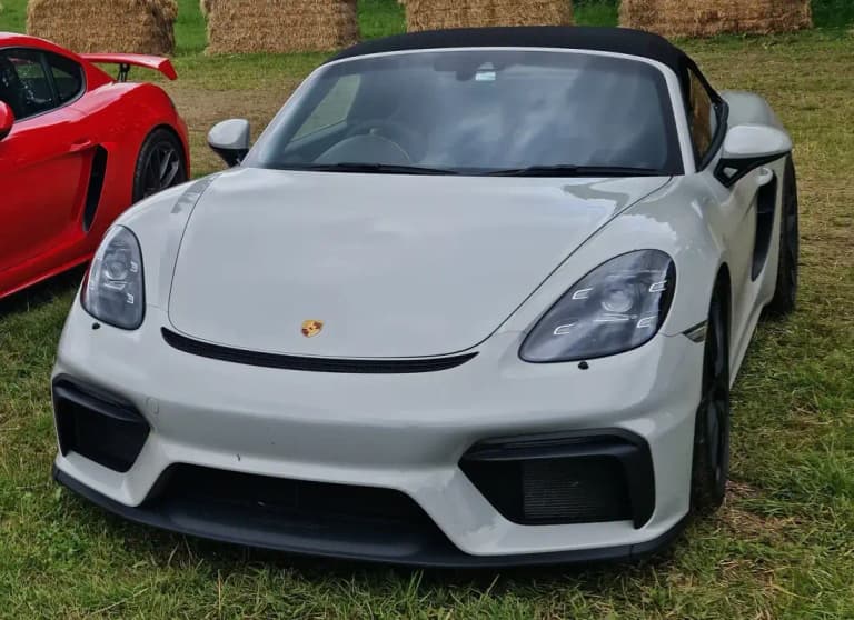 Gray Porsche 718 Spyder front view showing the low nose and black soft top