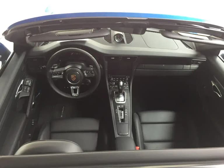 Black Porsche 911 Carrera GTS cockpit showing the steering wheel, PDK shifter and Sport Chrono dash clock