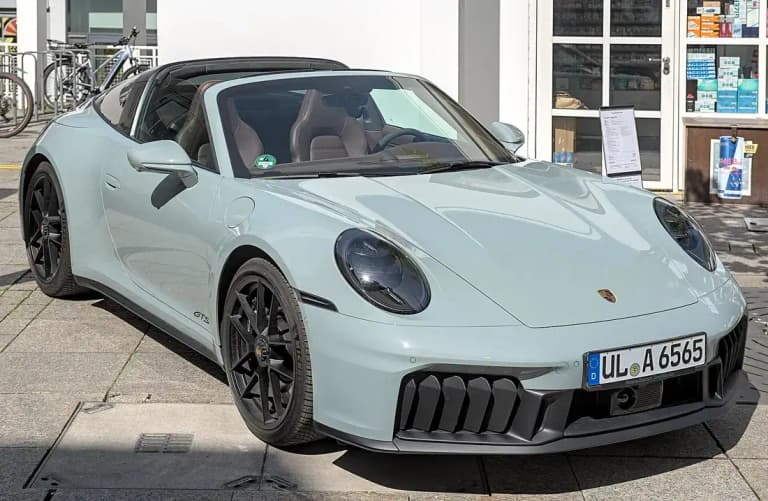 Light green Porsche 992 Carrera GTS Targa 4 with the roof closed, black wheels and GTS badge