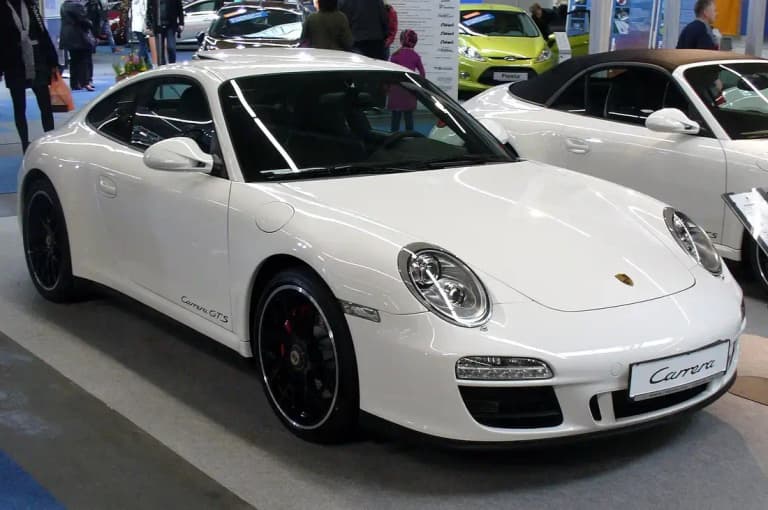 White Porsche 997 Carrera GTS coupe with black center-lock wheels and Carrera GTS door script