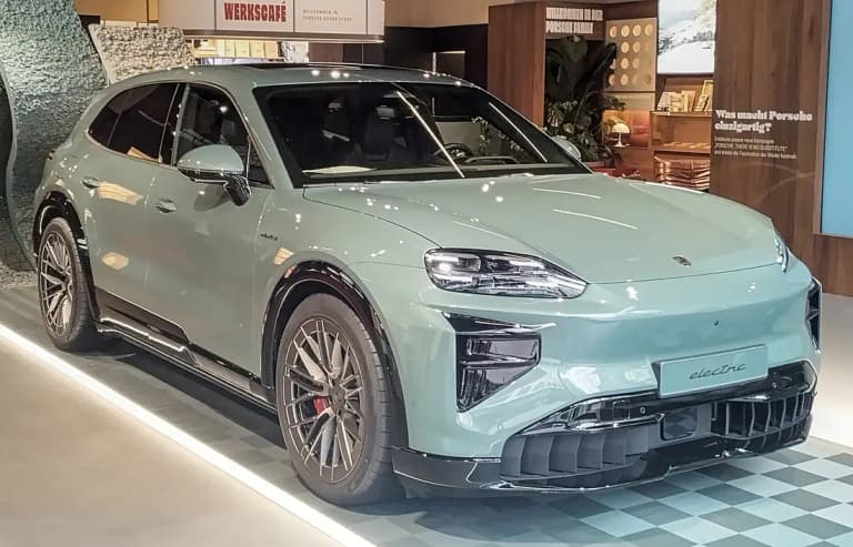 Green Porsche Cayenne Electric front three-quarter view at a Porsche brand store