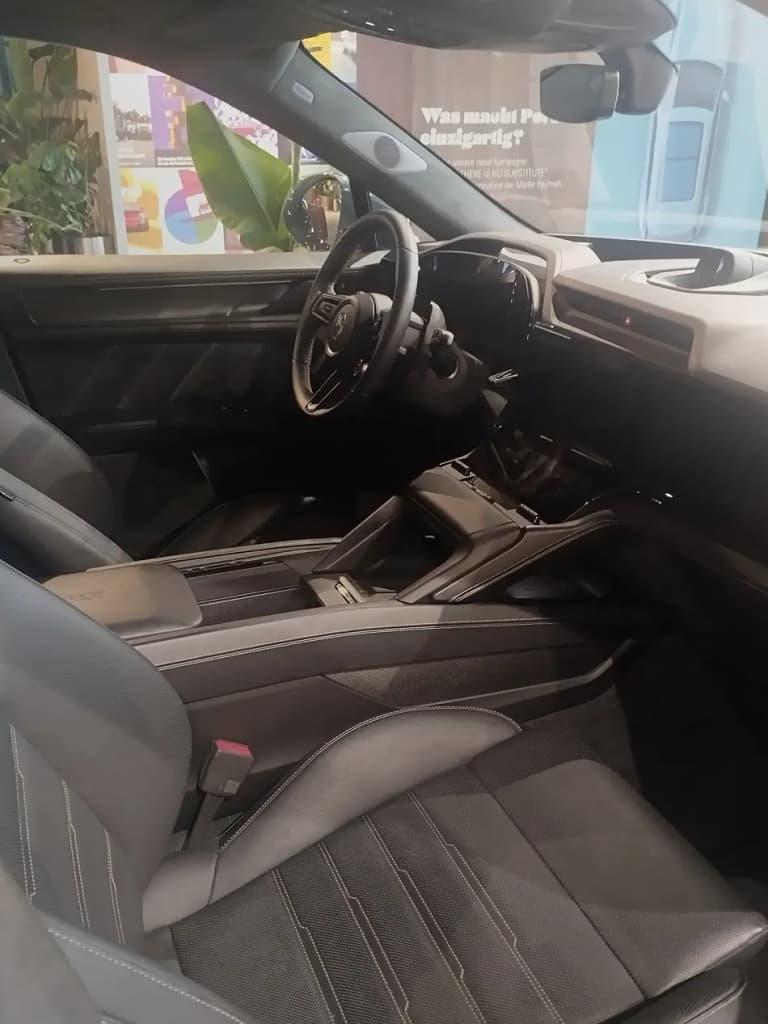 Porsche Cayenne Electric interior showing the driver seat, steering wheel, and center console