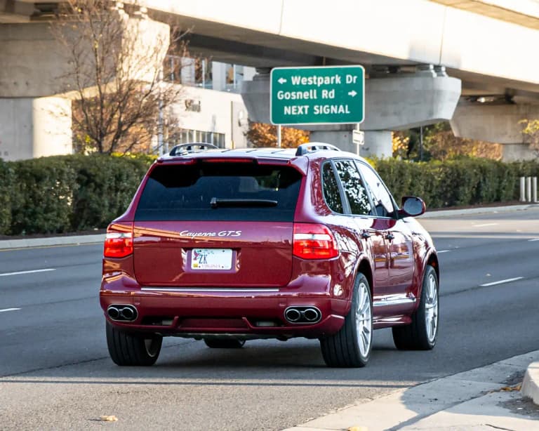 Dark red first-generation Porsche Cayenne GTS SUV, rear view with quad exhaust tips