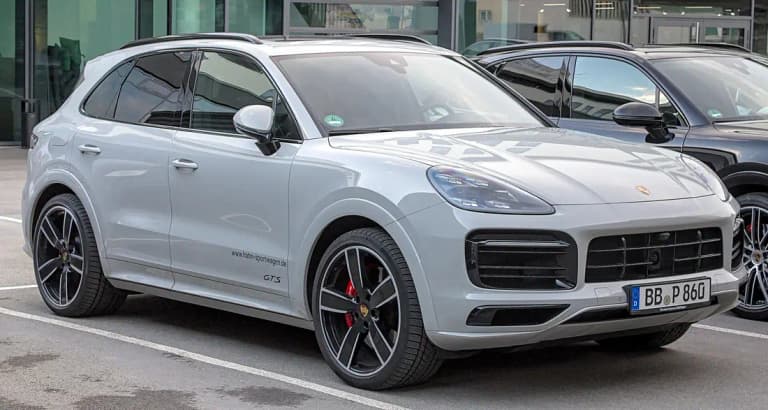 Light gray Porsche Cayenne GTS SUV, front three-quarter view with red brake calipers and GTS door badge