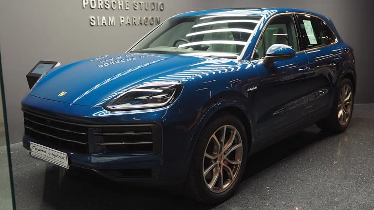 Blue Porsche Cayenne E-Hybrid in a showroom, front three-quarter view