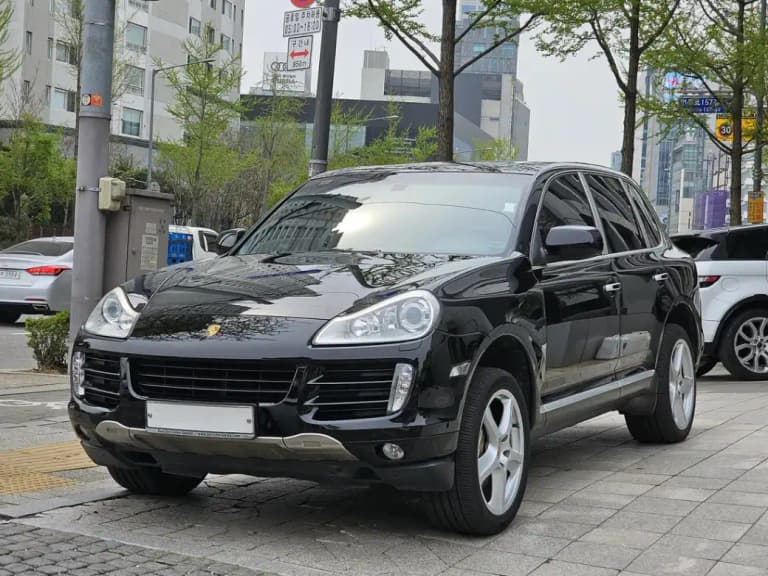 Black first-generation facelift Porsche Cayenne S (957), front three-quarter view