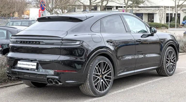 Black Porsche Cayenne S Coupe, rear three-quarter view showing the fastback roofline and quad tailpipes