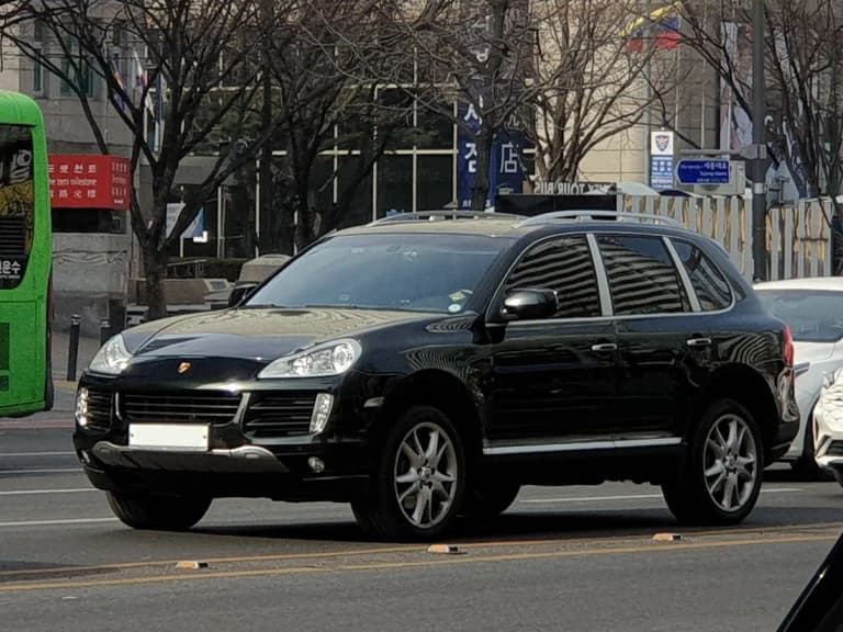 Black first-generation Porsche Cayenne S parked on a city street