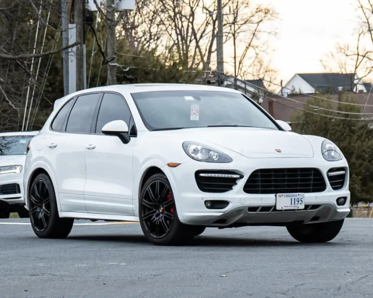 White Porsche Cayenne Turbo (958) with black wheels, front three-quarter view