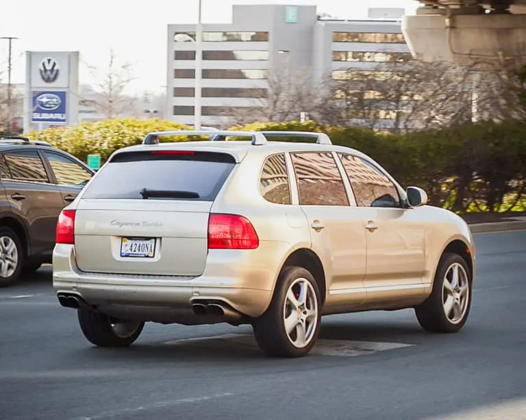 Gold first-generation Porsche Cayenne Turbo (955), rear three-quarter view on a street