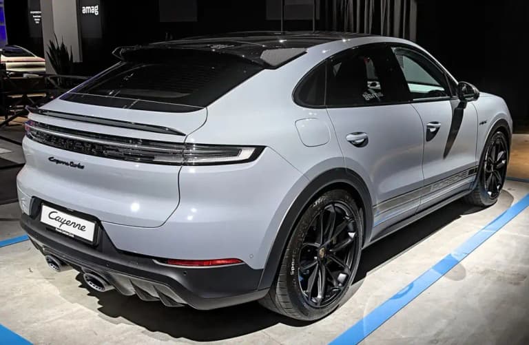 Gray Porsche Cayenne Turbo E-Hybrid Coupe, rear three-quarter view on a show stand