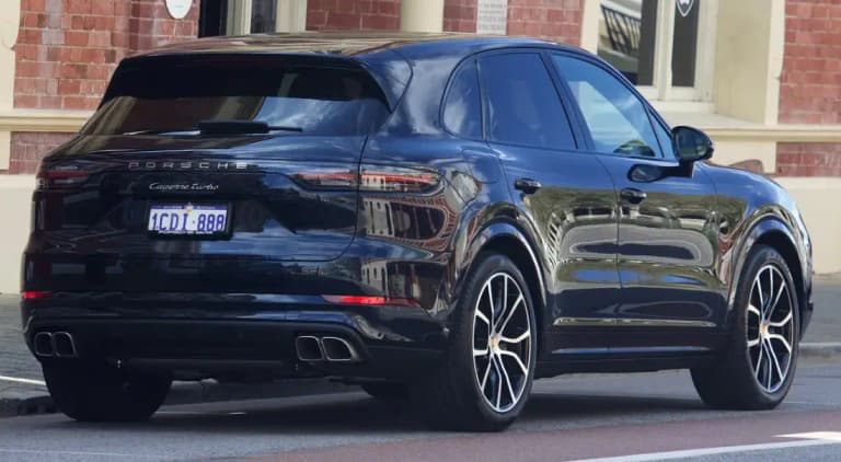 Black Porsche Cayenne Turbo (E3), rear three-quarter view showing quad exhausts
