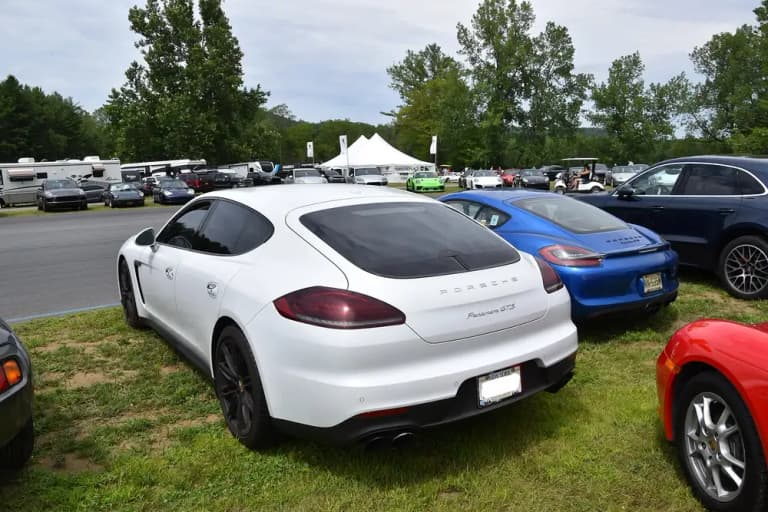 White first-generation Porsche Panamera GTS parked on grass at a Porsche event