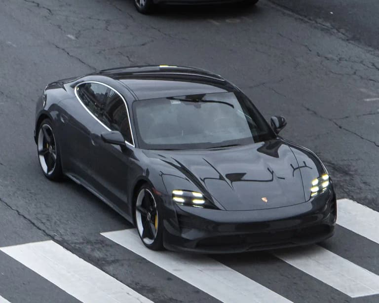Dark grey Porsche Taycan 4S front three-quarter view on a road crossing