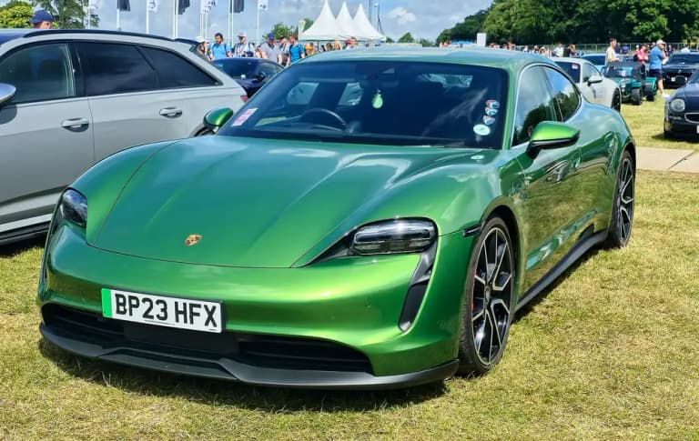 Green Porsche Taycan 4S front three-quarter view on grass at a car show