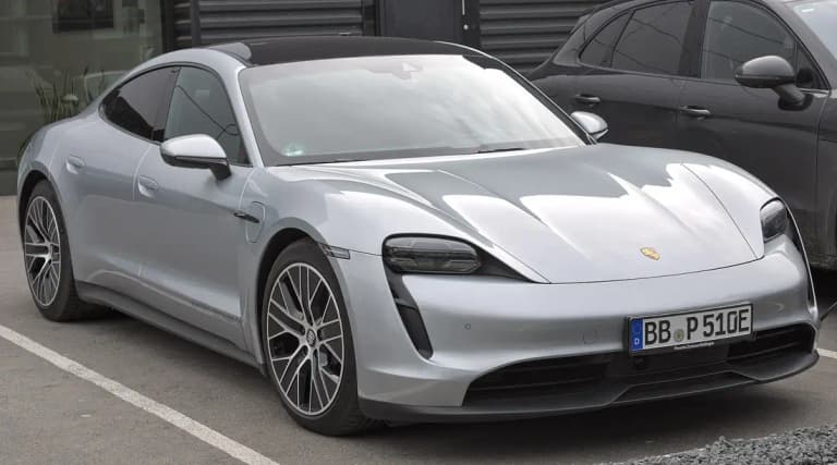 Silver Porsche Taycan 4S front three-quarter view in a parking bay