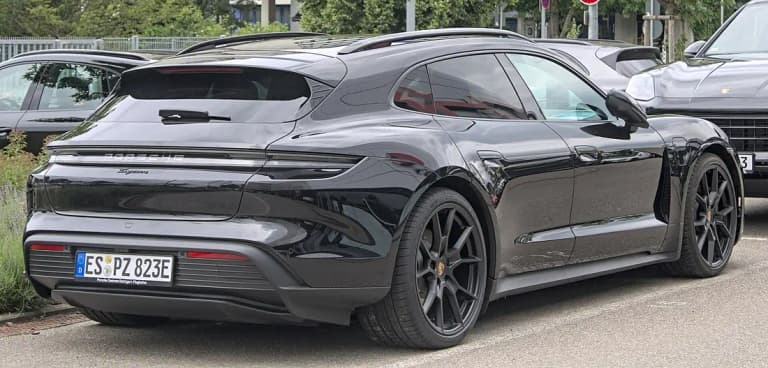 Black Porsche Taycan Cross Turismo rear three-quarter view showing raised ride height and cladding