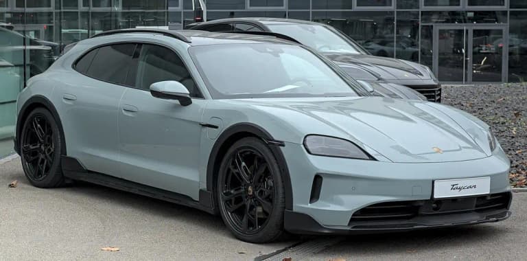 Grey Porsche Taycan Cross Turismo front three-quarter view with black wheel-arch cladding and roof rails